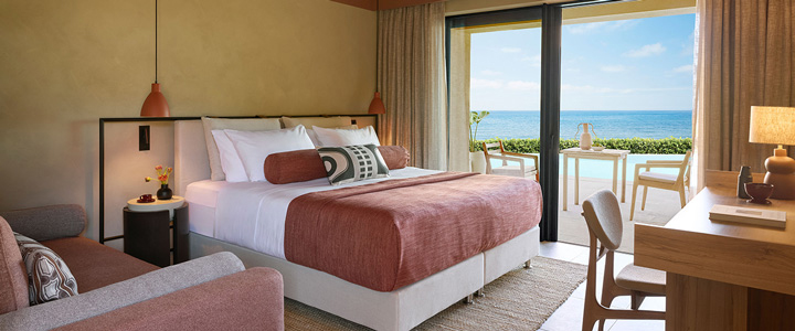 Stilvoll und warm eingerichtetes Doppelzimmer des Hotels ananea Rocrita mit Blick auf das Meer.